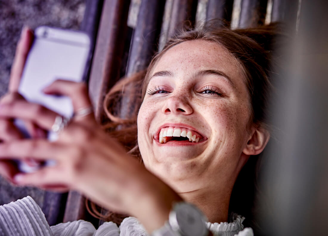 Woman smiling while looking at her phone