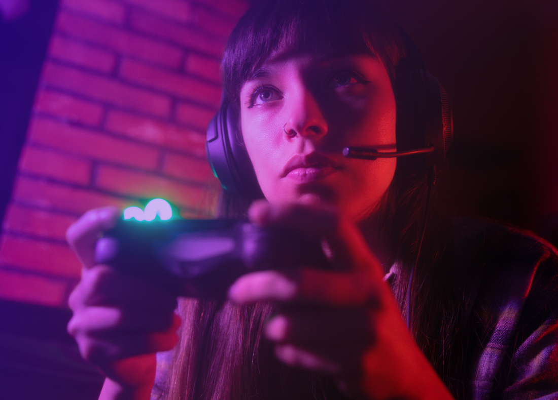 focused female gamer wearing a headset, holding a controller