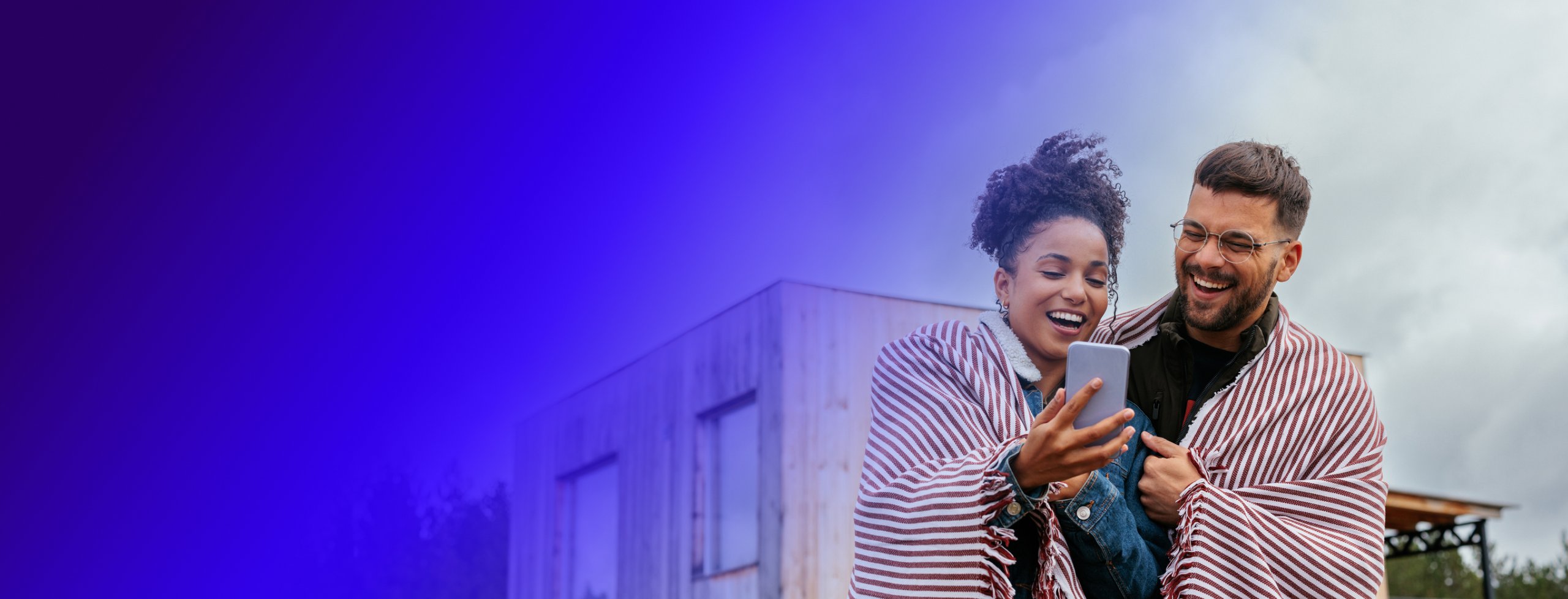 woman and man smiling and looking at a mobile phone