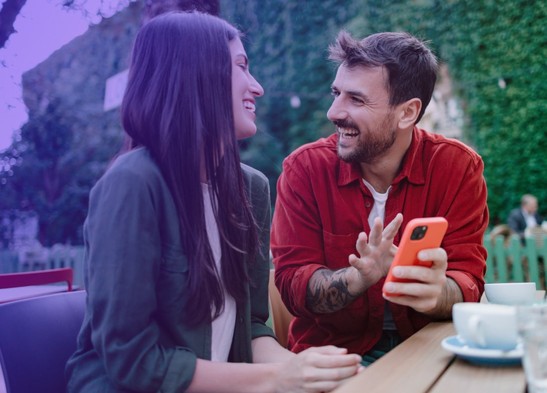 woman and man talking and laughing man is holding a phone