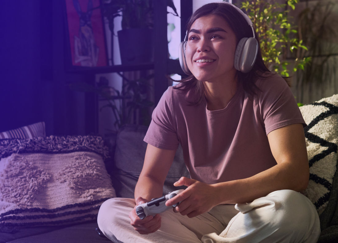 Person playing on their game console while laying on a couch