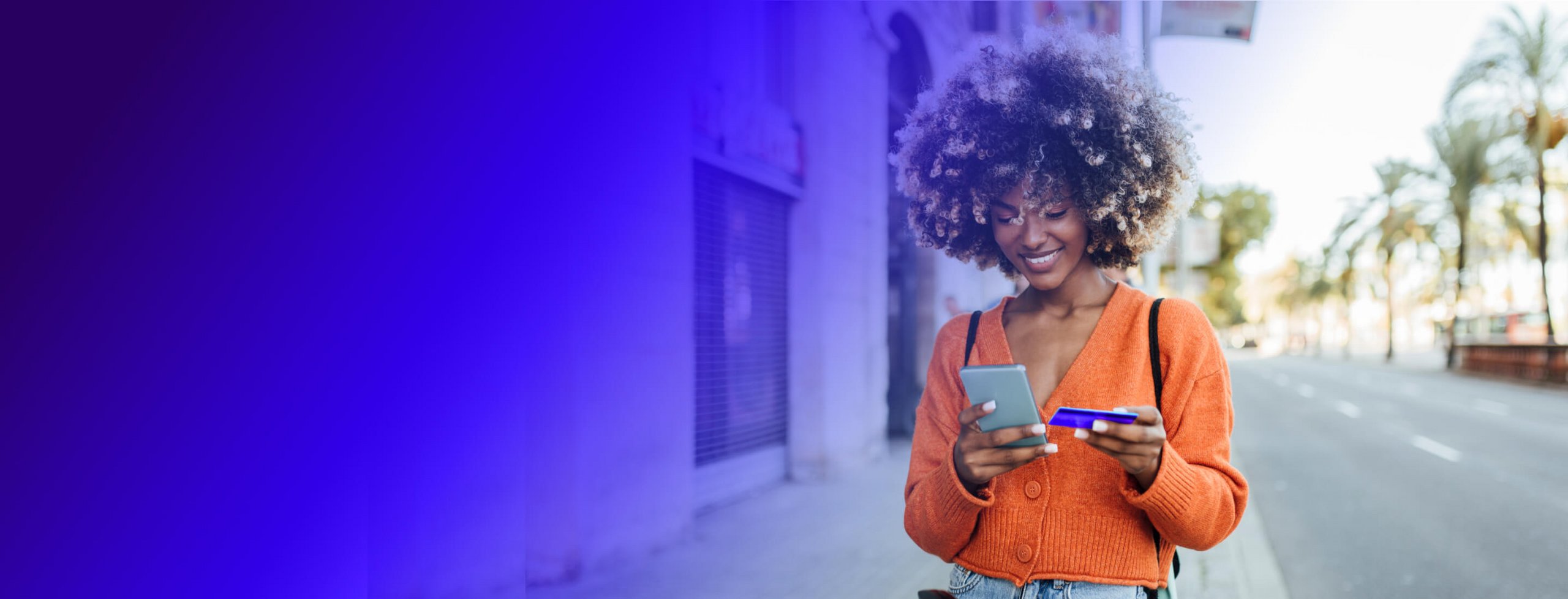 woman walking outside and using her prepaid card to pay
