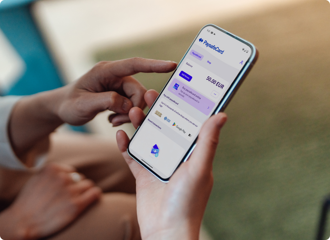 showing hands holding a phone showing the PaysafeCard account interface