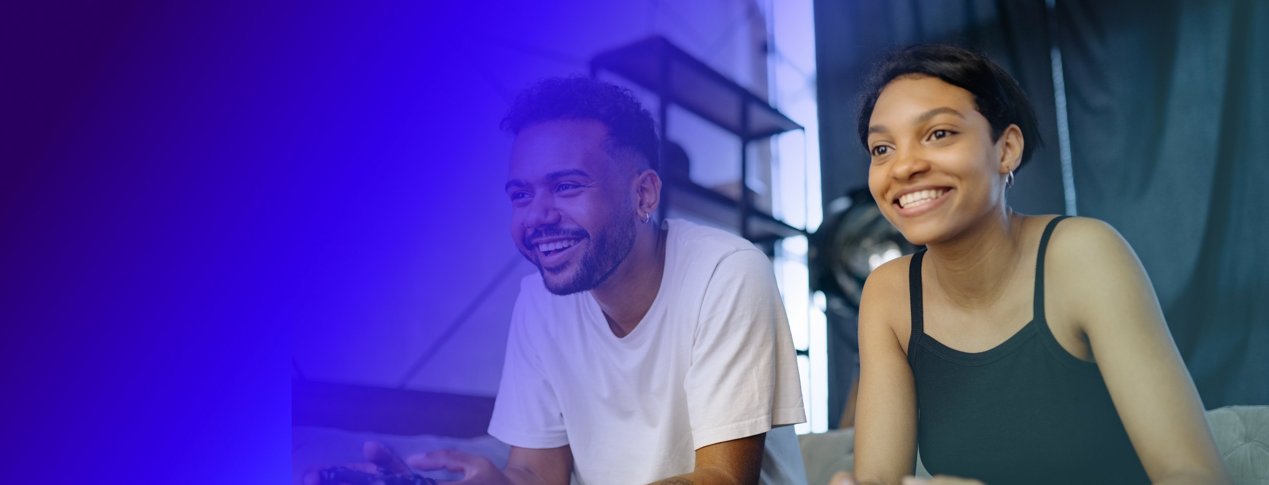 a young woman and a young man smiling playing video games on a game console