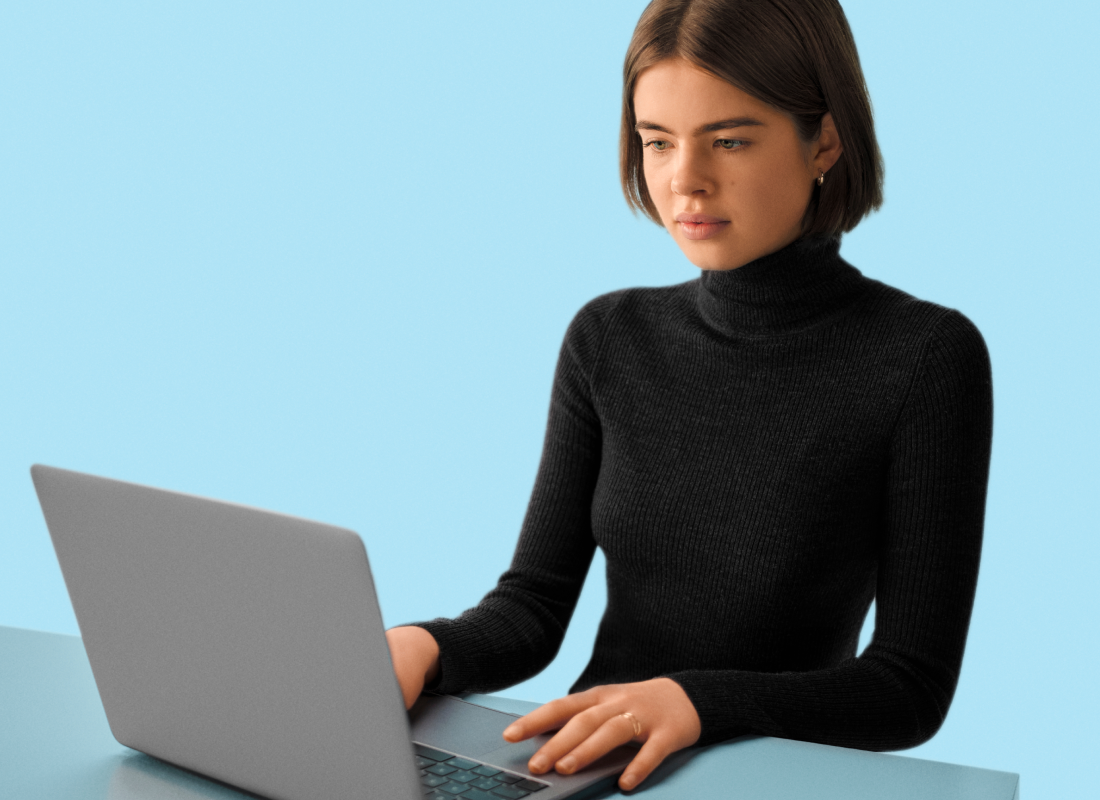 Lady in black sitting at desk using her laptop